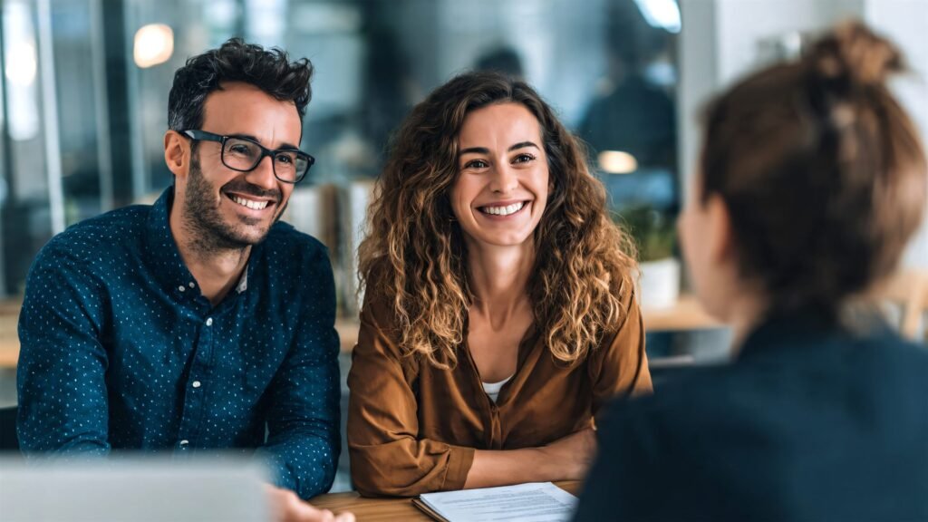 Two people smiling across a desk during a professional consultation